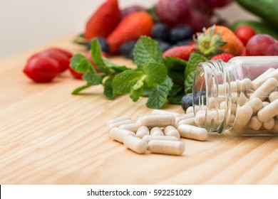 Vitamins supplements in bottle on wooden table.