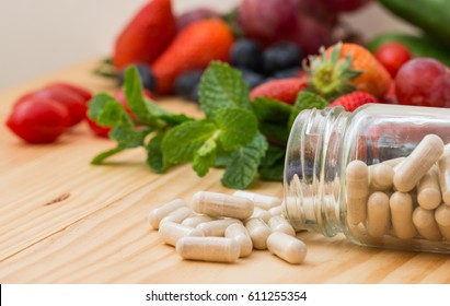 Vitamins supplements in the bottle and wooden table.
