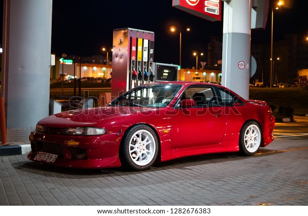 Vitebsk / Belarus - August 30, 2018: Photo of a
Nissan 200sx s14. Red  tuning, glossy stanced drift car at gas
station at night. Japan tuned Nissan silvia S14 zenki with sr20det
engine. Sport wheels.