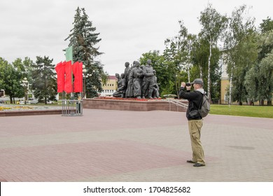 Vitebsk, Belarus - July 1, 2018: A Tourist With A Backpack Takes An Amateur Video On Victory Square On A Cloudy Day.