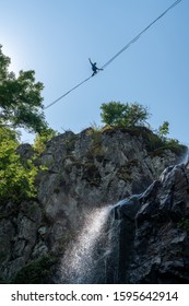 Vitosha, Nr Sofia / Bulgaria - 25 Aug 2019: An Intrepid Adventurer Uses A Tight Rope (high Wire), Suspended In Mid Air, To Traverse The Air Space Above The Boyana Waterfall Using His Arms For Balance.