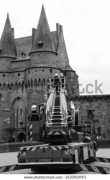 VITRE, FRANCE - JULY 12,\
2014: Firemen carry out training exercise near the castle of Vitre.\
The castle of Vitre was built in 11th century and rebuilt at 13th\
century.