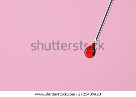 In vitro fertilization. Needle with liquid sample on pink background, closeup. Space for text