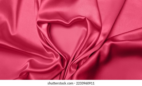 Viva Meganta toned red fabric atlas  Pink silk satin texture  Abstract background wallpaper Valentine's Day  February 14th  Twisted folds cloth heart shape sign  Trendy color the year 2023  

