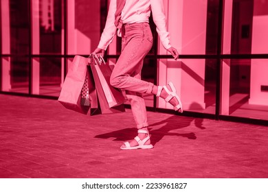 Viva Meganta toned red magenta european woman hold bags after shopping, retail store mall on the street sales black friday season. Trendy color of the year 2023. Fashion color pattern

