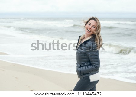 Similar – Woman walking on a beach on a cloudy day