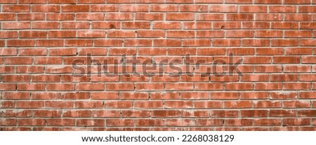 Vivid backdrop with old realistic red brick wall. Minimal fragment of orange brickwall close-up. Minimalist monochrome background with dirty wall of brown bricks close up. Simple wall texture.