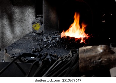 Vivid fire burning in a traditional forge with glowing coals, surrounded by blacksmith tools, capturing the essence of craftsmanship and old-world technology - Powered by Shutterstock