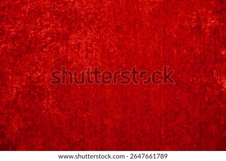 A vivid red background with a textured surface is suitable for use in graphic design projects. It offers copy space for adding text, logos, or other design elements.