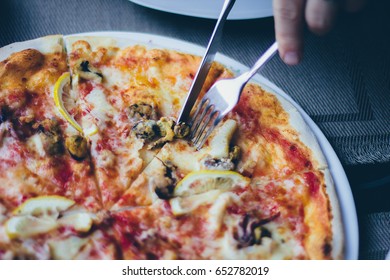 Vivid Shot Of Cut Piece Of Pizza With Fork And Knife