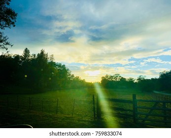 Vivid Sun through Clouds over Fence