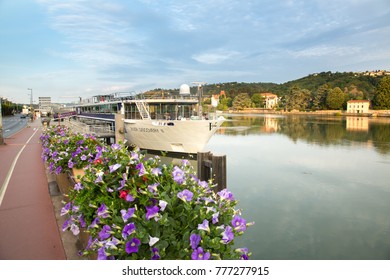 Viviers, France - 6/6/2015: 
 Flowers On The Sea Wall And A Viking River Cruise Ship Tied Up Along The Rhone River In Vienne, France