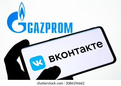 VK VKONTAKTE app logo seen on smartphone and GAZPROM logo on the blurred laptop. Word in russian translaed as "VKONTAKTE". Concept. Stafford, United Kingdom, December 5, 2021.