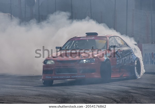 VLADIVOSTOK, RUSSIA - OCTOBER 02: Car\
drift, Sports car wheel drifts and a lot of smoke on the track.\
Russian drift show RDS without borders on October 02,\
2021.