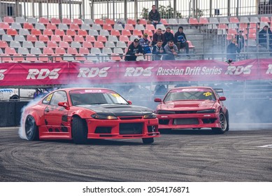 VLADIVOSTOK, RUSSIA - OCTOBER 02: Two Cars drift, Sports cars wheel drifts and a lot of smoke on the track. Russian drift show RDS without borders on October 02, 2021.