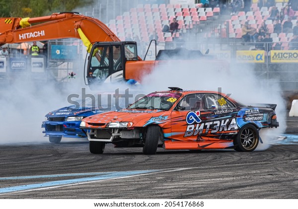 VLADIVOSTOK, RUSSIA - OCTOBER 02:\
Two Cars drift, Sports cars wheel drifts and a lot of smoke on the\
track. Russian drift show RDS without borders on October 02,\
2021.