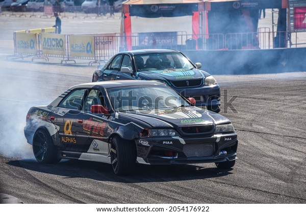 VLADIVOSTOK, RUSSIA - OCTOBER 02:\
Two Cars drift, Sports cars wheel drifts and a lot of smoke on the\
track. Russian drift show RDS without borders on October 02,\
2021.