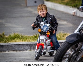 VLADIVOSTOK, RUSSIA, October 03, 2015: A happy little boy driving a toy motorcycle in closing-time of a motorcycle season in Vladivostok.