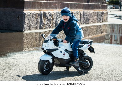 Vladivostok, Russia - on May 05, 2018: A happy little boy driving a toy motorcycle during the holiday on the occasion of opening of a season of motorcycles.