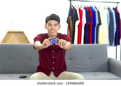 A vlogger showing a credit card. His store accept payment by credit card.