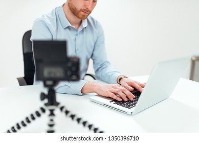 Vlogger using laptop while making video, close-up.