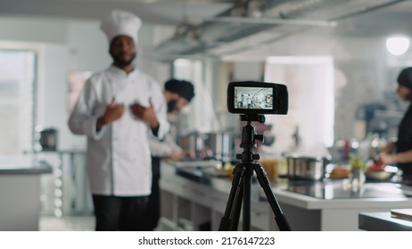 Vlogging Camera Filming Male Cook On Television Cooking Show, Talking About Gastronomy And Cuisine. Gourmet Chef In Uniform Giving Online Food Lesson, Recording Video On Camera. Tripod Shot.