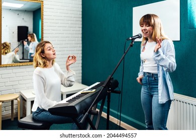 Vocal coach training her student's voice on a lesson - Shutterstock ID 2044494557