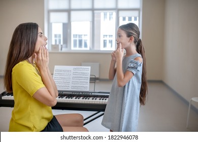 Vocal Lesson. Girl In Blue Dress And Her Teacher Doing Voice Exercises