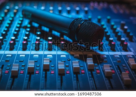 Vocal microphone and sound table or audio mixer, professional sound equipment for live musicians, singers, sound technicians and music producers.