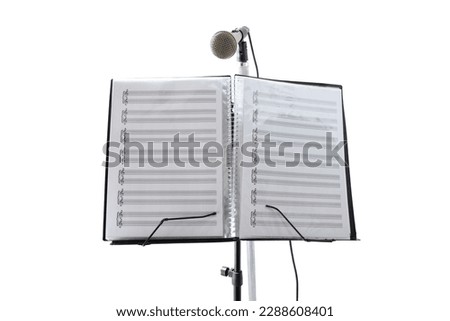 Vocal music stand with sheet music and microphone in large bright interior room with golden lights. Front view