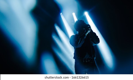 vocalist performing on stage at a concert in the fog. Dark background, smoke, concert  spotlights. - Powered by Shutterstock