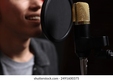 Vocalist singing into microphone in professional record studio, closeup - Powered by Shutterstock