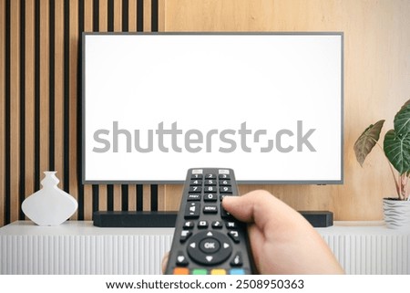 VOD service screen. Man watching TV with remote control in hand.