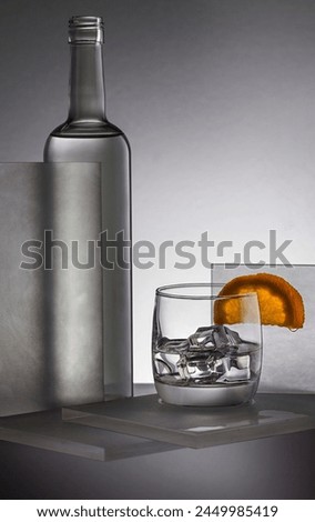 Vodka bottle with glass ice and slice of orange professional photography