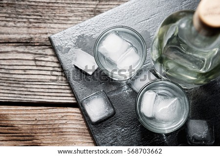 Vodka gin in shot glasses on rustic wood background top view