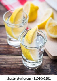 Vodka With Lemon In Shot Glass On Wooden Background