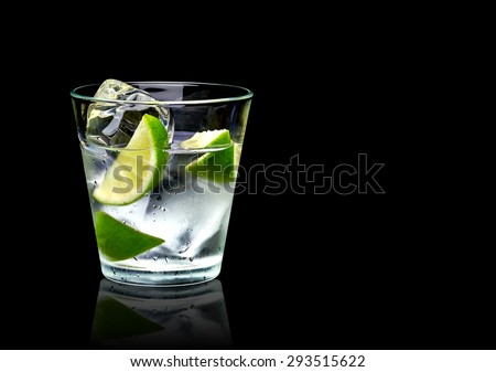 Vodka lime mojito or gin tonic  with ice in rocks glass on black background including clipping path
