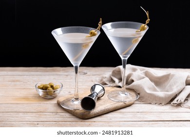 Vodka martini cocktail with vodka and vermouth and green olives on wooden table - Powered by Shutterstock