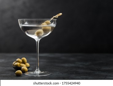 Vodka Martini Gin Cocktail In Modern Glass With Olives In Metal Bowl And Bamboo Sticks On Black Background.