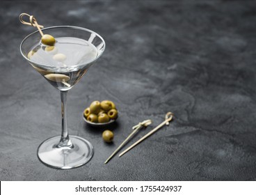 Vodka Martini Gin Cocktail In Original Glass With Olives In Metal Bowl And Bamboo Sticks On Black Background.