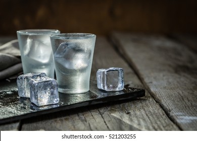 Vodka in shot glasses on rustic wood background - Shutterstock ID 521203255