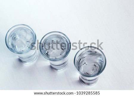vodka shots with ice on a white background