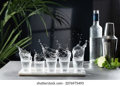 Vodka splash in shot glasses at the bar. - Shutterstock ID 2076975493