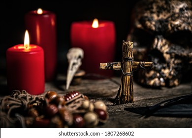 Vodun or voodoo ritual table with candles, puppet and a human skull, black magician and religion