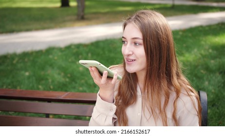 Voice Assistant. Student Speak With A Virtual Assistant. Voice Recognition. Woman Uses Smartphone Outdoor.