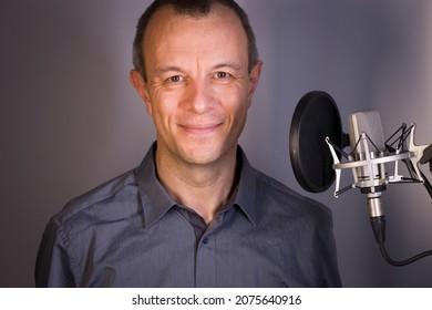 Voiceover Artist Voice Actor In Vocal Recording Studio With Larg Diaphragm Microphone And Antipop Shield.