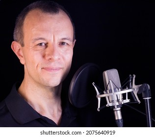 Voiceover Artist Voice Actor In Vocal Recording Studio With Larg Diaphragm Microphone And Antipop Shield.