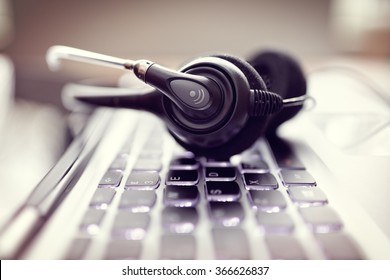 VOIP headset on laptop computer keyboard concept for communication, it support, call center and customer service help desk - Shutterstock ID 366626837