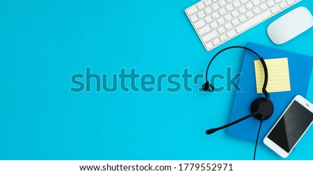 VOIP Helpdesk headset, keyboard computer notebook and mouse isolated on blue background. Communication support for callcenter and customer service Helpdesk