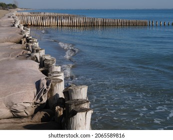 Volano Beach, Ferrara. Sandy Beach In Northern Italy. Sandbags And Poles To Defend The Coast From The Erosion Of Storm Surges.